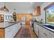 Modern kitchen featuring bright white cabinets, hardwood floors, stainless appliances, and outdoor views at 7633 S Gilpin Ct, Centennial, CO 80122
