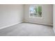 A bright, carpeted bedroom with a large window showing a tree-lined street at 4623 S Kalispell Way, Aurora, CO 80015