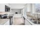 Renovated kitchen featuring granite countertops, stainless appliances, and an open view to the living room at 4623 S Kalispell Way, Aurora, CO 80015