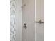 Close up of a shower tiled with neutral tiles and an accent of colorful decorative tiles at 4623 S Kalispell Way, Aurora, CO 80015