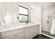 Contemporary bathroom featuring dual vanities, a large mirror, and a glass-enclosed shower at 263 S Jackson St, Denver, CO 80209