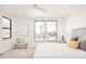 Sunlit bedroom with large windows, ceiling fan, stylish accent chair, and a cozy bed with decorative pillows at 263 S Jackson St, Denver, CO 80209
