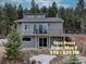 Charming gray two-story home with a spacious deck and beautiful forest surroundings at 31932 Steven Way, Conifer, CO 80433