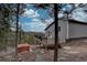 Side exterior featuring a deck overlooking a wooded landscape, complete with a hot tub for relaxation at 31932 Steven Way, Conifer, CO 80433