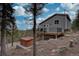 Charming gray home with a deck, hot tub, and mountain views, blending comfort and natural beauty at 31932 Steven Way, Conifer, CO 80433