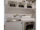 Efficient laundry room with modern washer and dryer, ample storage space, and organized shelving at 31932 Steven Way, Conifer, CO 80433
