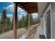 Underneath deck showing forest, post support, and walkway with wall mount lighting at 31932 Steven Way, Conifer, CO 80433