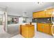 A kitchen with wood cabinets, neutral walls, an open layout, and a kitchen island at 1121 Albion St # 305, Denver, CO 80220
