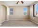 Neutral bedroom with carpet, a ceiling fan, and two windows, providing a bright and adaptable living space at 16149 E Geddes Ln # 99, Aurora, CO 80016