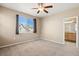 Inviting bedroom with neutral carpet, a ceiling fan, and access to bathroom, creating a functional and relaxing retreat at 16149 E Geddes Ln # 99, Aurora, CO 80016