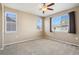 Well-lit bedroom with three windows, ceiling fan, and neutral carpet, offering a bright and inviting atmosphere at 16149 E Geddes Ln # 99, Aurora, CO 80016