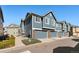 Townhouse garages with contemporary gray doors, exterior brick detail, and tidy landscaping at 16149 E Geddes Ln # 99, Aurora, CO 80016