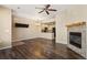 Well-lit living room featuring hardwood floors, a fireplace, and an open kitchen layout at 16149 E Geddes Ln # 99, Aurora, CO 80016