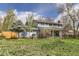 A spacious backyard with lush green grass, trees, and a view of the home's exterior at 4707 Ashfield Ct, Boulder, CO 80301