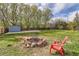 A large backyard featuring a stone fire pit, a plastic chair, mature trees, and a storage shed at 4707 Ashfield Ct, Boulder, CO 80301