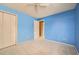 Bedroom with blue walls, carpeted floors, and view to bedroom door and walk-in closet at 4707 Ashfield Ct, Boulder, CO 80301
