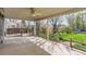 Covered patio with ceiling fan overlooking fenced yard with mature trees and lush green grass at 4707 Ashfield Ct, Boulder, CO 80301