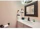 Cozy powder room with bronze fixtures, a framed mirror, and decorative hand towels at 4707 Ashfield Ct, Boulder, CO 80301