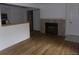 Open-concept living room with wood floors and a cozy fireplace near the kitchen area at 6705 S Field St # 802, Littleton, CO 80128