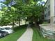 Exterior shot of a community sidewalk surrounded by mature trees and manicured landscaping, offering a serene environment at 6705 S Field St # 802, Littleton, CO 80128