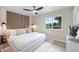 This bright bedroom features a wood accent wall, large window, and modern ceiling fan at 13249 W Jewell Pl, Denver, CO 80228