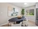 Cozy dining area featuring modern decor, natural light, stainless steel refrigerator and wood floors at 13249 W Jewell Pl, Denver, CO 80228