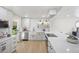 Modern white kitchen featuring stainless steel appliances, subway tile and light hardwood floors at 13249 W Jewell Pl, Denver, CO 80228
