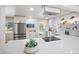 Bright kitchen with stainless steel appliances, quartz countertop and stylish white cabinetry at 13249 W Jewell Pl, Denver, CO 80228