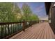 Spacious back porch with scenic views of lush trees, a lake, and mountains at 3900 Bogey Ct, Longmont, CO 80503