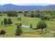 Beautiful golf course view with water features and mountain backdrop at 3900 Bogey Ct, Longmont, CO 80503