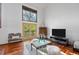 Bright living area with large windows, hardwood floors, and sliding doors leading to a balcony at 3900 Bogey Ct, Longmont, CO 80503