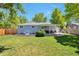 Spacious backyard featuring a well-manicured lawn and an inviting covered patio perfect for outdoor gatherings at 6179 S Bemis St, Littleton, CO 80120