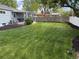 Large backyard with a covered deck, lush green grass, mulch beds and a wood fence at 6179 S Bemis St, Littleton, CO 80120