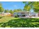 Expansive backyard with lush lawn, patio, and shade, ideal for outdoor living and entertaining at 6179 S Bemis St, Littleton, CO 80120