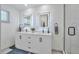 Elegant bathroom with double vanity, illuminated mirrors, and glass enclosed shower at 6179 S Bemis St, Littleton, CO 80120