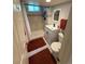 Bathroom with tile shower, white vanity and dark red bathmats at 6179 S Bemis St, Littleton, CO 80120