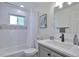 Well-lit bathroom featuring a modern vanity, updated fixtures, and shower-tub combination at 6179 S Bemis St, Littleton, CO 80120