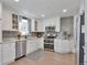 Modern kitchen featuring white cabinets, stainless steel appliances, and granite countertops at 6179 S Bemis St, Littleton, CO 80120
