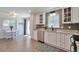 Bright eat-in kitchen with white cabinetry, stainless steel appliances, and stylish backsplash at 6179 S Bemis St, Littleton, CO 80120