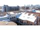 Snow-covered rooftops of townhouses with city skyline in background at 3195 Blake St # 201, Denver, CO 80205