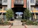Landscaped entrance into a gated condominium complex with mature trees and planters at 3195 Blake St # 201, Denver, CO 80205
