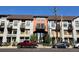 Multi-story mixed use building showing retail and residences and vehicles parked on the street at 3195 Blake St # 201, Denver, CO 80205