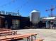 Outdoor patio area with multiple picnic tables, adjacent to a brewery at 3195 Blake St # 201, Denver, CO 80205