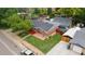 Charming brick home with a spacious yard and mature trees, featuring a red porch and an inviting exterior at 1263 W 103Rd Pl, Northglenn, CO 80260
