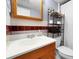 Bathroom featuring a vanity, sink, wooden mirror, stylish tiles, toilet, and shower with curtain at 1263 W 103Rd Pl, Northglenn, CO 80260