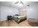 Bedroom with hardwood floors, a cozy bed with pillows, side table, and natural light at 1263 W 103Rd Pl, Northglenn, CO 80260