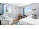 A bright bedroom with a bed, an armchair, and two windows letting in natural light at 1263 W 103Rd Pl, Northglenn, CO 80260