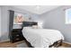 An interior bedroom showcasing a bed with a decorative headboard and light blue walls at 1263 W 103Rd Pl, Northglenn, CO 80260