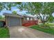 Charming home with a front-facing garage and a red porch, surrounded by a green lawn and mature trees at 1263 W 103Rd Pl, Northglenn, CO 80260