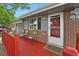 Charming front porch features a cozy seating area, providing a welcoming entrance to this brick and gray home at 1263 W 103Rd Pl, Northglenn, CO 80260